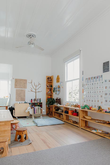 Bright, tidy preschool learning room with toys on shelves and learning materials on the walls